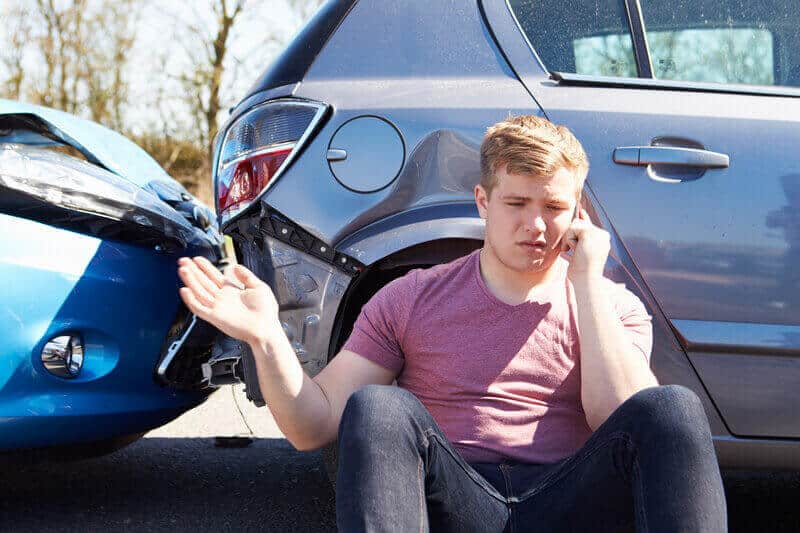 man leaning on car on phone