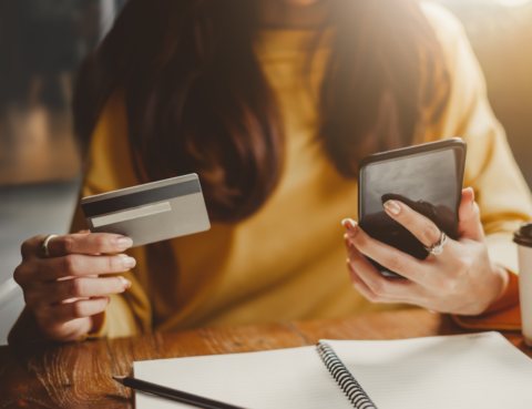 woman holding phone and credit card